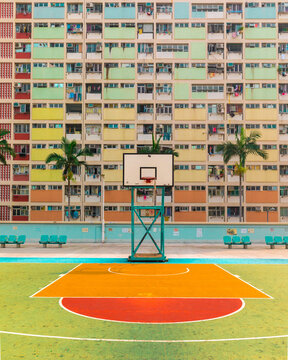 View of the vibrant basketball court and the iconic pastel-colored residential facade of Choi Hung Estate Hong Kong.