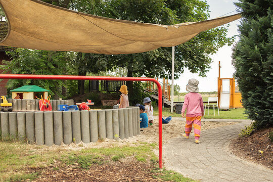 Kindergartenkinder spielen drau&szlig;en auf dem Spielplatz.
