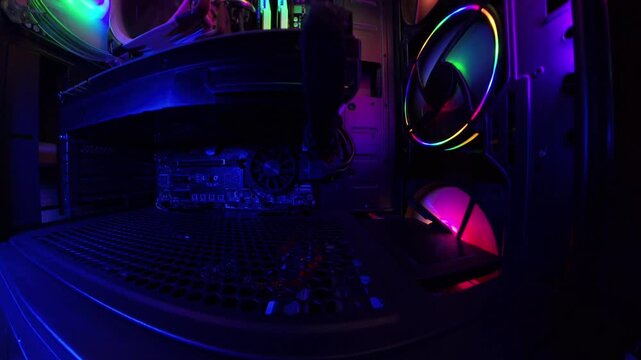 A close-up, slider shot inside a gaming PC, showcasing vibrant RGB lighting, cooling fans, and hardware components. The smooth camera movement highlights the intricate details of the high-tech setup i