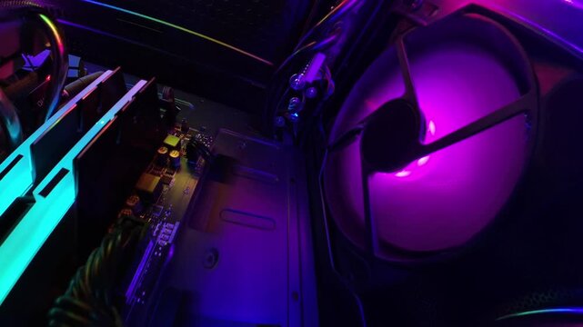 A wide-angle camera captures close-up views of the interior of a gaming PC, moving in different directions to showcase glowing RGB lights, cooling fans, and detailed hardware components in a high-tech