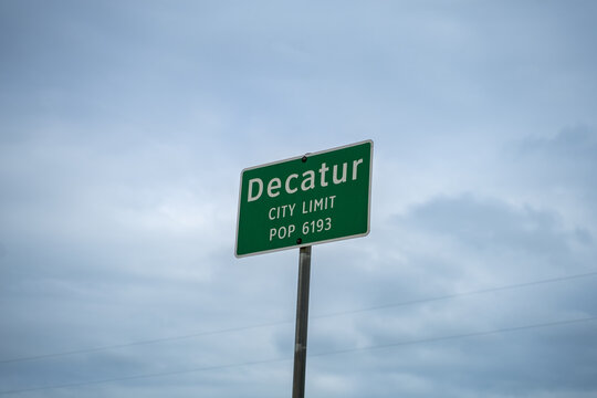 Green Decatur City Limit Sign With Cloudy Sky in Decatur, Texas