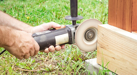 Worker cuts wood with hand-held power tool © Sergei