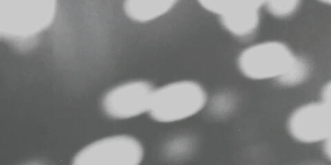 Abstract background featuring soft out of focus bokeh light spots on a dark grey textured surface Vector, illustration © md
