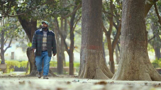 Man walking with smartphone, casual moment of a man walking while holding a smartphone, everyday lifestyle vibe, modern connection, natural light, candid feel, relatable and simple story