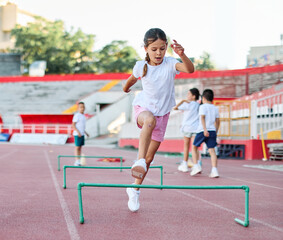Obraz premium Children running on track at the stadium, practice during sports class in school training with their coach teacher, little fit boys and girls in sportswear training as athletes outdoor. Concept of sp
