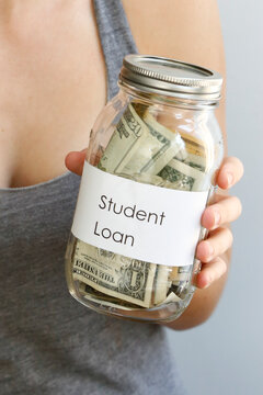 College Savings Concept with Cash in Jar Held by Woman