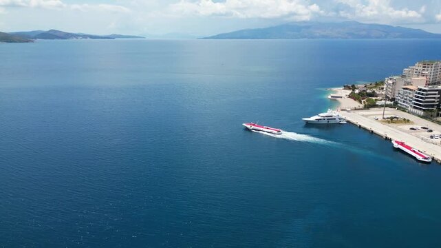 Saranda Albania Speedboat Departure Aerial Drone 4K &ndash; Fast Boat Leaving Harbor, Ionian Sea, Corfu Island in Background, Coastal Travel Destination Europe