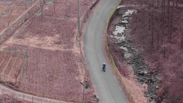 Cinematic motorcycle riding on Scenic route with a mountain creek with synchronized real exhaust sound_Telephoto