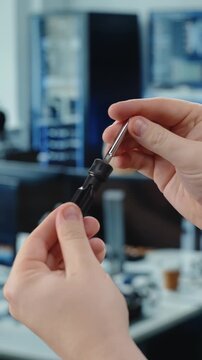 Hands reversing screwdriver bit in office workspace