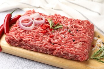 Fototapeta premium Raw minced beef and spices on light grey table, closeup