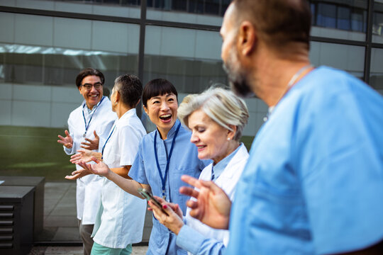 Group of doctors and nurses talking outside hospital