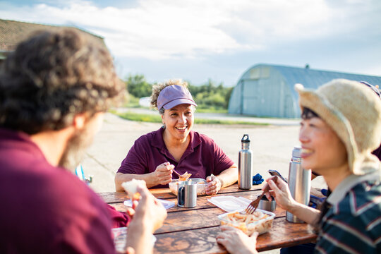 Farm workers eating lunch outdoors at picnic table