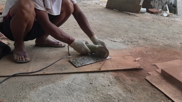 Worker Cutting Ceramic Tiles Using Hand Grinder Tool