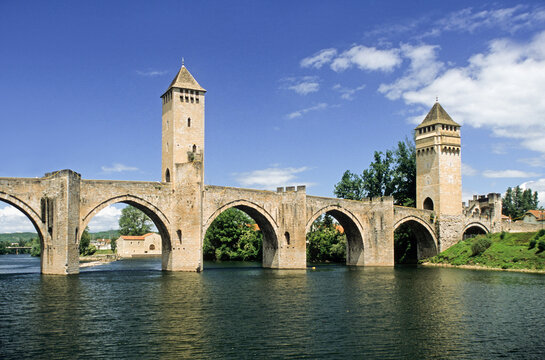 Exploring Pont Valentre in Cahors, a historic bridge in southern France by the Lot river under a blue sky