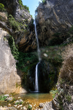 Waterfall flowing down in Loup River gorges surrounded by cliffs in southeastern France
