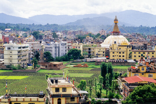 Bodnath Temple rises above Kathmandu with surrounding buildings and fields in the distance, located in Nepal, Himalaya region of South Asia