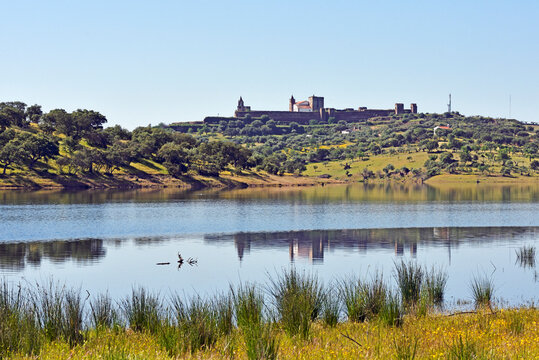 View of Alqueva dam lake with reflections and castle on Guadiana River near Mourao in Alentejo Portugal