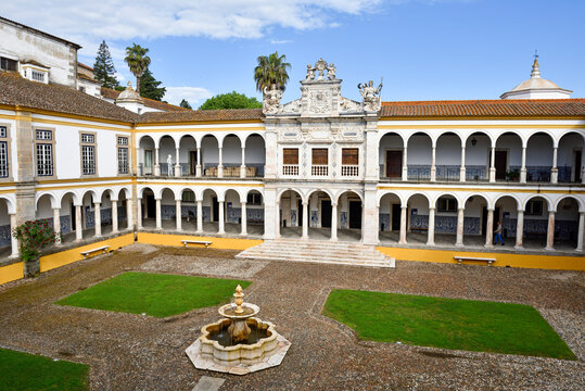 Courtyard of the Former Colegio do Espirito Santo in Evora, Portugal with fountain and gardens during a sunny day