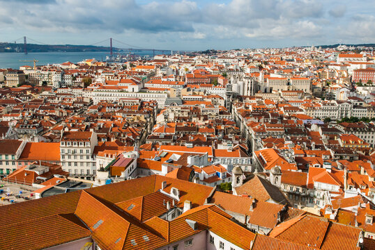View of Baixa and Chiado districts from Sao Jorge Castle with Tage River in background in Lisbon, Portugal with rooftops and cityscape