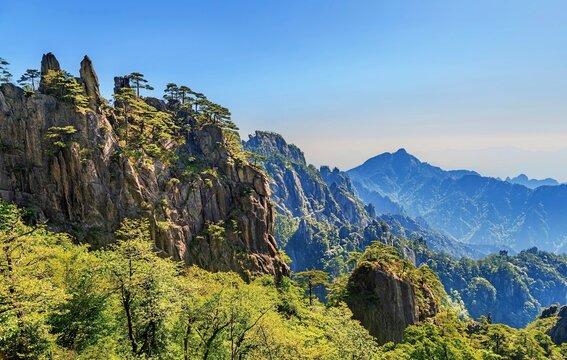 Mount Huangshan offers views of rocky peaks and green trees in Anhui Province, China during a clear sunny day