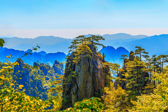 Explore the stunning rock formations and trees of Huangshan in Anhui Province, China, against a backdrop of distant mountains