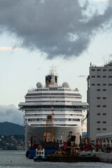 Fototapeta premium Cruise ship in Port of Savona with industrial dock and service vessels. Savona, Italy