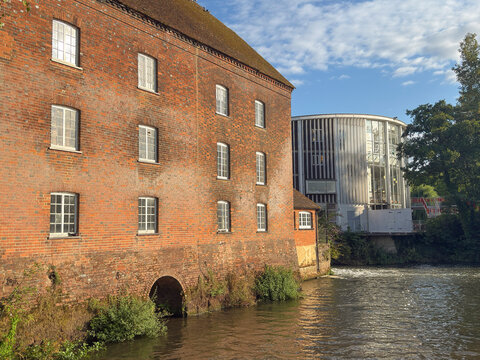 View of Town Mills and Yvonne Arnaud Theatre along the River Wey in Guildford, Surrey, showing brick buildings and water features