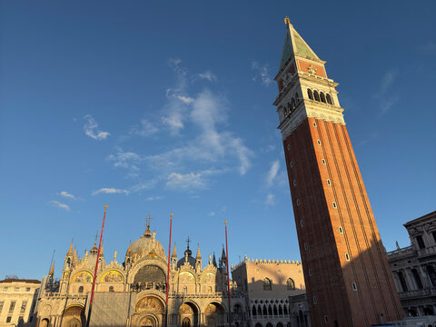 Evening light illuminates Campanile and Basilica at St Marks Square in Venice Italy