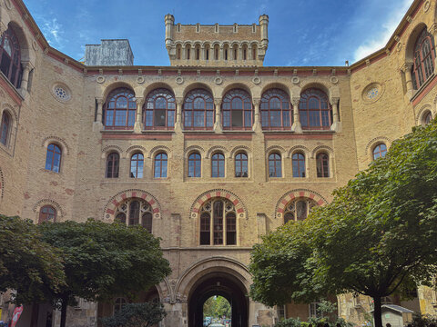 Brick facade of historic building in Vienna showcasing architectural details with trees in the foreground