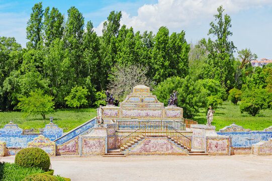 Exploring the gardens of Queluz National Palace in Lisbon, Portugal with green trees and unique structures