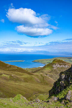 Explore the rugged hills and coastline of Trotternish escarpment in Isle of Skye Scotland on a bright clear day with blue skies
