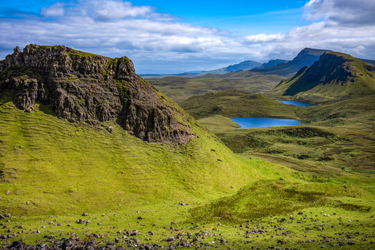 Rugged hills and lakes of Trotternish escarpment in Isle of Skye Scotland under clear skies