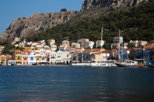 View of boats anchored in Megisti Bay with houses lining the harbor in Kastellorizo, Dodecanese Islands, Greece