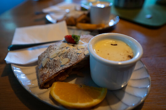 Visitors enjoy apple strudel at high altitude restaurant on sunny day in Austria with mountain views
