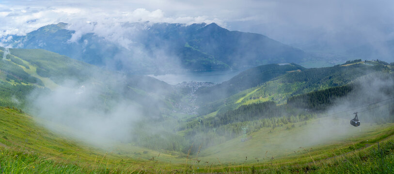 View from Schmittenhohebahn top station shows cable car and landscape near Zell am See in Salzburg Austria on sunny day