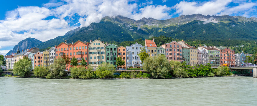 Colorful buildings line the River Inn on a sunny summer day in Innsbruck, Tyrol Region, Austria