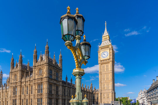 View of Big Ben from Westminster Bridge during summer in London, England with historical architecture in bright sky
