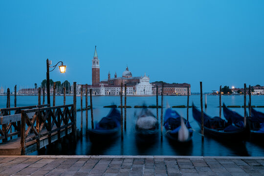 Goldolas on the lagoon at twilight with San Giorgio Maggiore in the background in Venice, Italy
