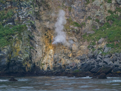Steam vents release gas from rocks on Kagamil Island in the Aleutian Archipelago, Alaska during a clear day