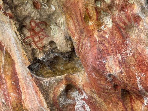 Ancient rock art found on limestone cliffs in Berau Bay on Papua Island, Indonesia showing historical cultural practices