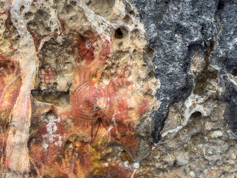 Ancient rock art on limestone cliffs in Berau Bay, Papua, Indonesia showcases historical significance and cultural heritage