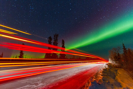 Long exposure of Jeep lights under the Aurora Borealis at Great Slave Lake in Northwest Territories Canada