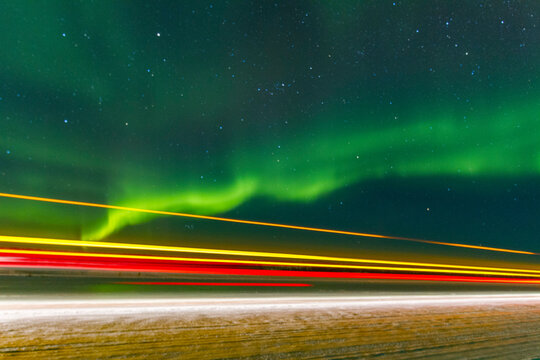 Long exposure captures Jeep lights beneath the aurora borealis over Great Slave Lake in Canada at night