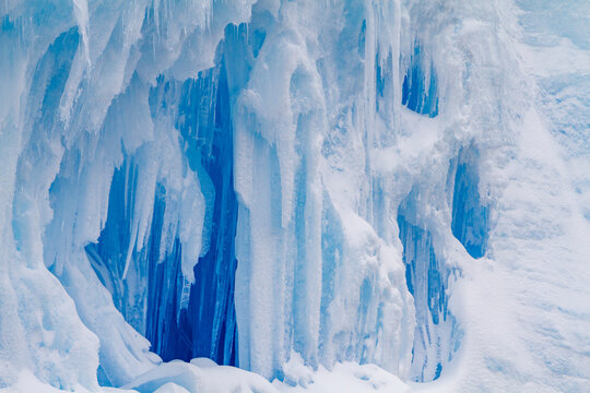 Iceberg detail with blue hues showing ice and snow patterns during summer in Antarctica