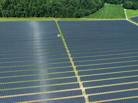 Solar panels covering large area in Upper Swabia region of Baden-Wurttemberg, Germany with green fields nearby
