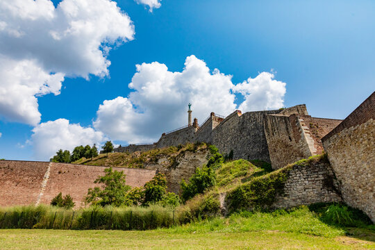 View of Kalemegdan Fortress stone walls rising over grassy slopes under blue skies