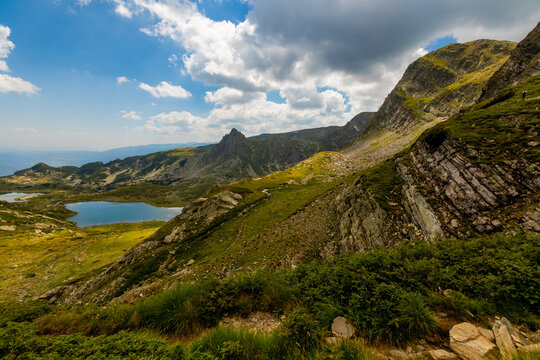 Multiple mountain lakes and rocky slopes in Rila Mountains under partly cloudy sky in Bulgaria