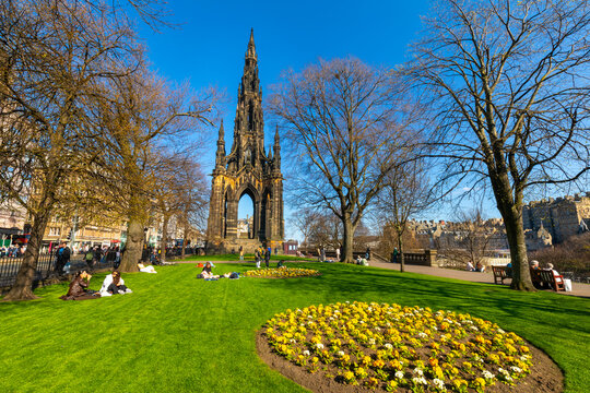 People relax in East Princes Street Gardens near the Sir Walter Scott Monument in Edinburgh on a sunny day