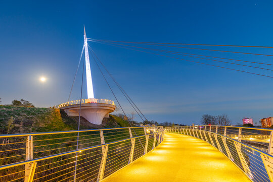 Stockingfield Bridge connects pathways over Forth and Clyde Canal during evening hours in Glasgow, Scotland