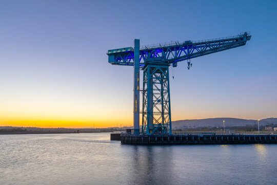 Clydebank Titan crane stands tall along the River Clyde during dusk in Clydebank, Scotland with a colorful sky